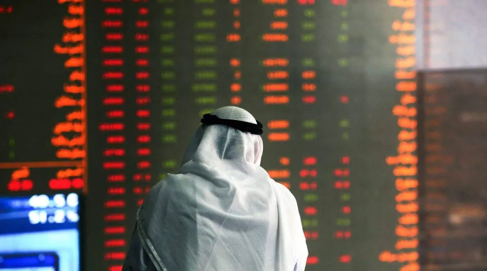 مستثمر في البورصة الكويتية يتابع شاشة أسهم متراجعة (أ.ف.ب)