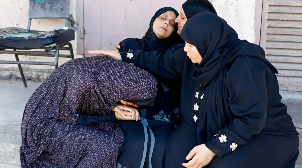 أقارب قتلى فلسطينيين في مستشفى شهداء الأقصى بدير البلح بمدينة غزة (رويترز)