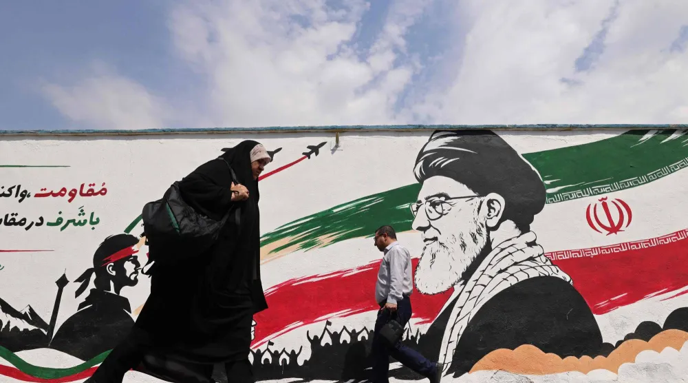 مشاة يسيرون أمام جدارية للمرشد الإيراني الراحل علي خامنئي على طول أحد شوارع وسط طهران 31 أغسطس 2026 (أ.ف.ب)