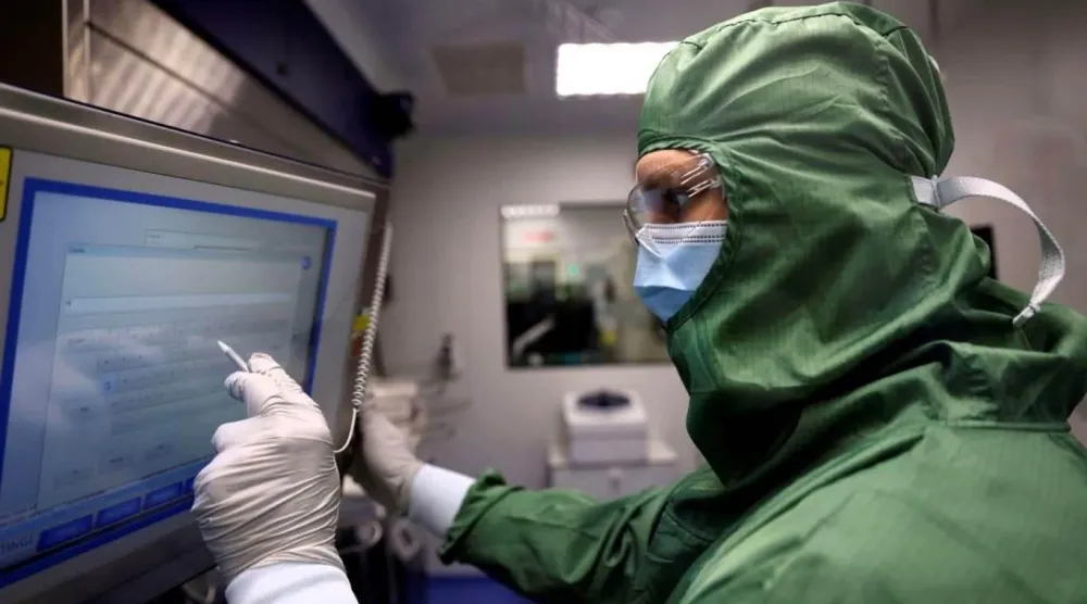 Paris'teki Fransız biyofarmasötik şirketi Cellectis'in laboratuvarındaki laboratuvar teknisyenleri, kanser tedavileri için CAR-T hücreleri ve RNA üretmek üzere 23 Eylül 2021'de bir makinede çalışıyor (Thomas Coex/AFP)