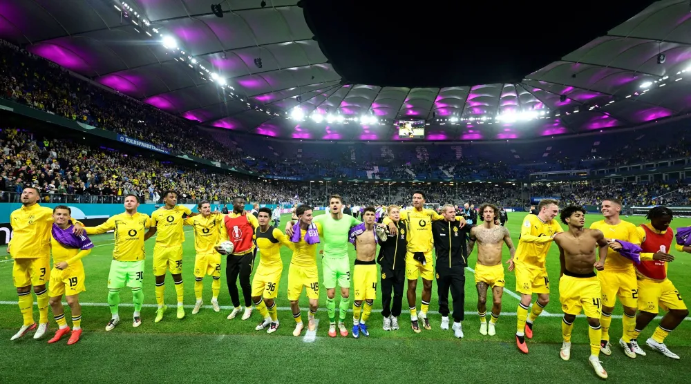 لاعبو بوروسيا دورتموند يحيون جماهيرهم الزائرة بهامبورغ (رويترز)
