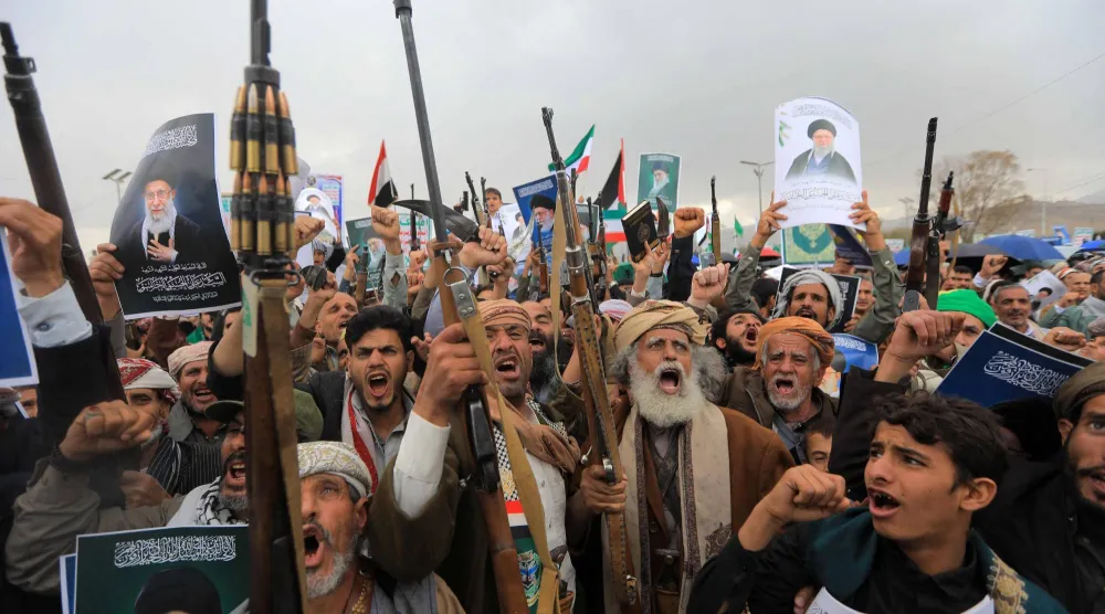 مسلحون حوثيون يرفعون صور خامنئي خلال حشد تعبوي في صنعاء (أ.ف.ب)