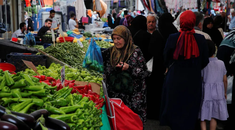يتسوّق أشخاص في سوق للمواد الغذائية الطازجة في إسطنبول (رويترز)