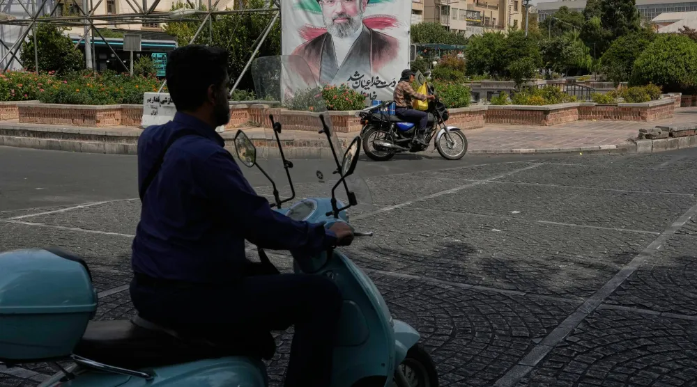  Men drive past a banner showing a portrait of the Iranian Supreme Leader Mojtaba Khamenei, in downtown Tehran, Iran, Monday, Aug. 31, 2026. (AP) 