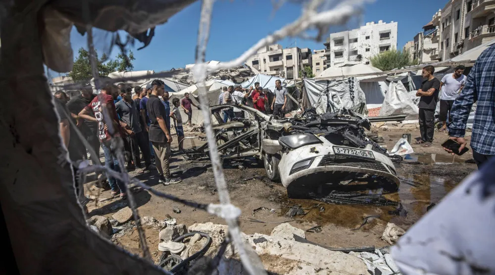 فلسطينيون بموقع غارة إسرائيلية بمدينة غزة يوم الثلاثاء الماضي واكبت اختطاف مسؤول أمني في «حماس» (إ.ب.أ)