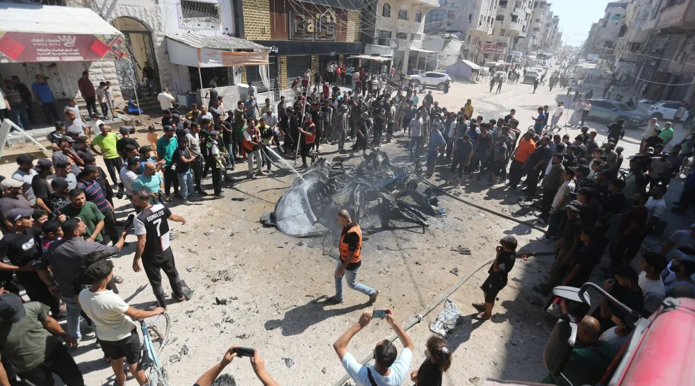 فلسطينيون يحيطون بسيارة محروقة إثر استهدافها بغارة في ضاحية تل الهوا في 31 أغسطس 2026 (د.ب.أ)