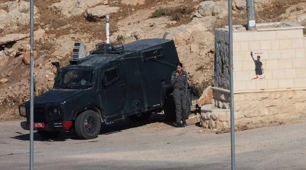جنود إسرائيليون على متن مركبة عسكرية يراقبون قرب قرية المغير الفلسطينية في الضفة الغربية (إ.ب.أ)
