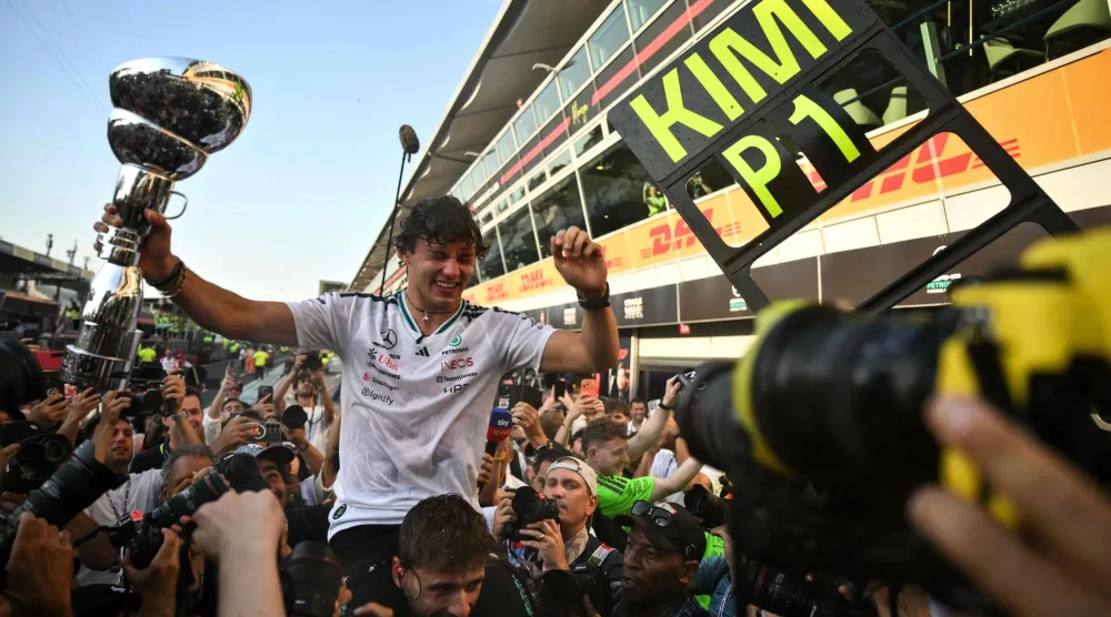 Mercedes' Italian driver Kimi Antonelli holds his trophy as he celebrates with his team members after winning the Italian Formula One Grand Prix at the Autodromo Nazionale Monza circuit in Monza, northern Italy on September 6, 2026. (AFP)