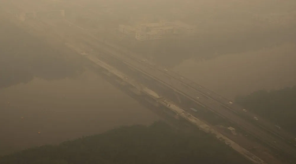This aerial photo taken from a commercial aircraft shows haze from Indonesian forest fires blanketing a bridge in Kuching, the capital city of Malaysia's Sarawak state on the island of Borneo on September 5, 2026. (AFP)