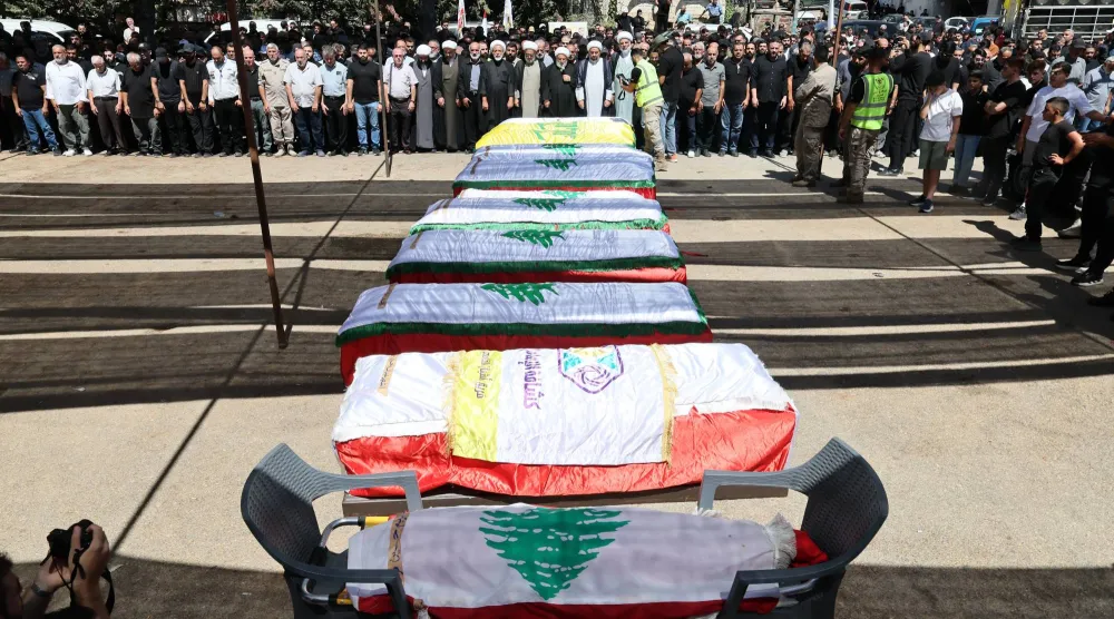 نعوش 12 شخصاً بينهم مقاتلان في «حزب الله» وأطفال قتلوا خلال غارة إسرائيلية استهدفت بلدة كفر رمان بجنوب لبنان الاثنين (إ.ب.أ)