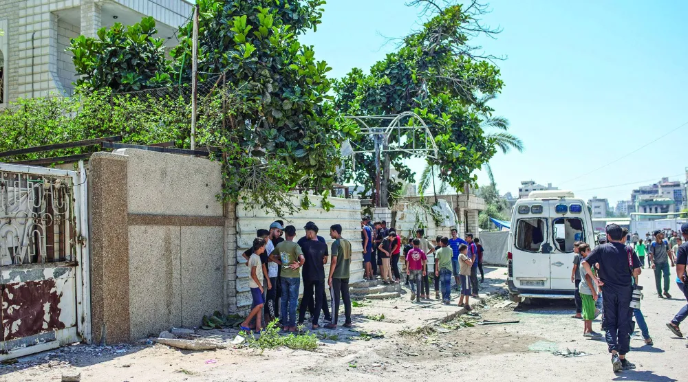 فلسطينيون قرب منزل المسؤول الأمني في «حماس» الذي تعرض لهجوم إسرائيلي أسفر عن اختطافه يوم الثلاثاء الماضي (إ.ب.أ)