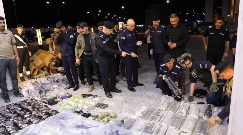 ضباط من الشرطة في الأنبار العراقية يعاينون مقذوفات ومسيرات تم ضبطها في المحافظة (إعلام أمني)
