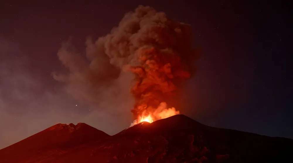 Volcanic material and fumes rise from Mount Etna during an eruption under a starry sky in Sicily, Italy, July 30, 2026. (Reuters) 
