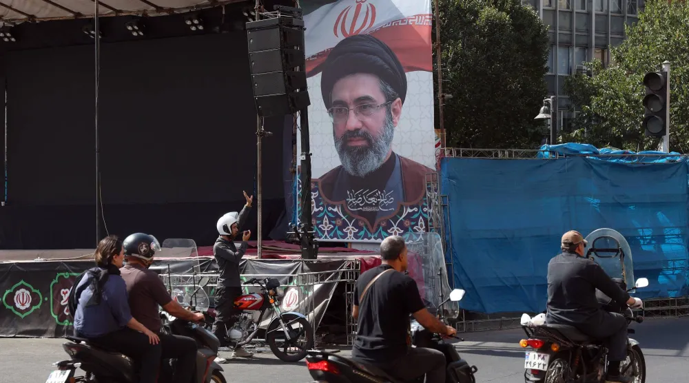 Iranians drive past a billboard of Iranian supreme leader Mojtaba Khamenei in a street in central Tehran, Iran, 13 September 2026. (EPA)