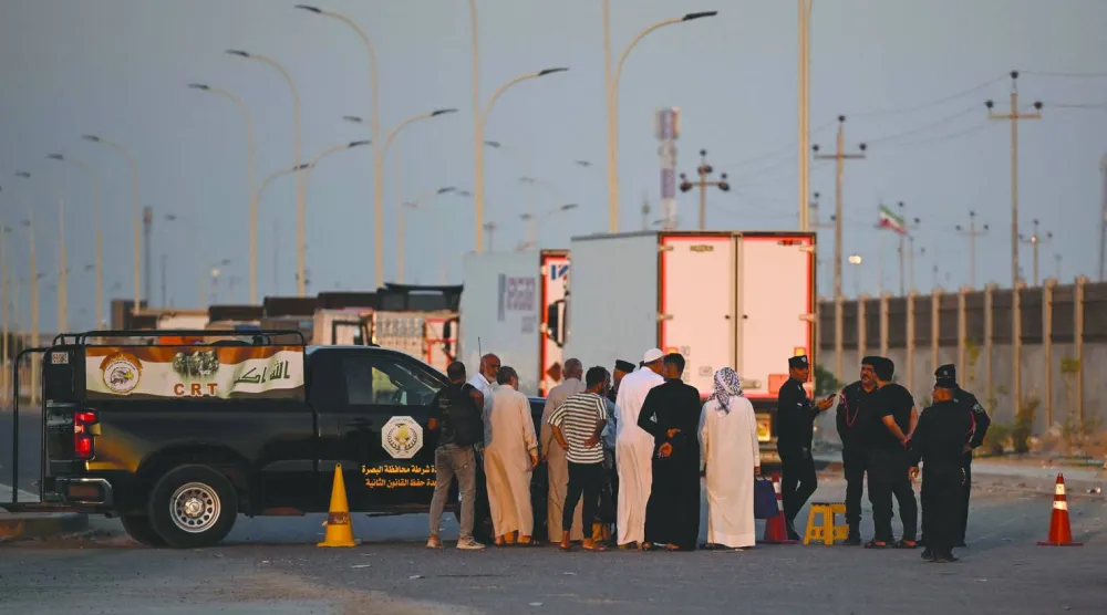 مواطنون ورجال أمن عند الجانب العراقي من معبر الشلامجة (أ.ف.ب)