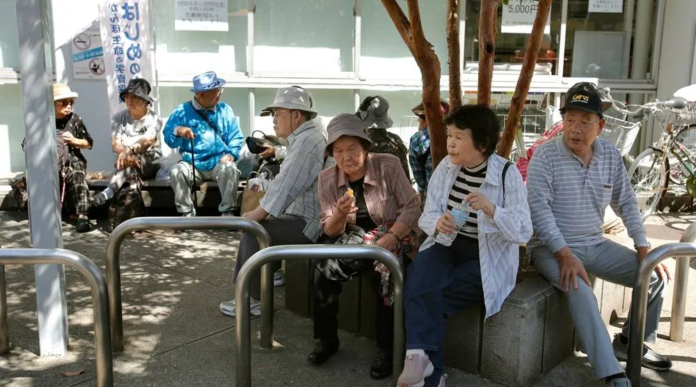Elderly people rest under the shade of a tree in Tokyo, Sunday, Sept. 14, 2014. (AP)