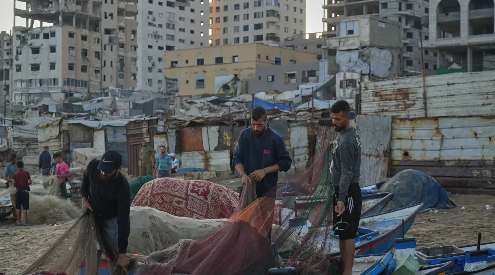 صيادون فلسطينيون يعملون على شباك صيدهم صباح الأحد 13 سبتمبر 2026 في ميناء مدينة غزة المتضرر من جراء الحرب (أ.ب)
