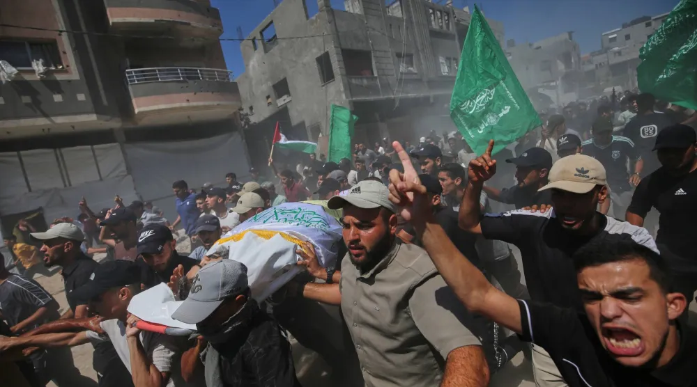 فلسطينيون يحملون جثمان نائل أبو عبيد قائد لواء رفح يوم الأربعاء بعد اغتياله في غارة إسرائيلية بخان يونس (أ.ب)