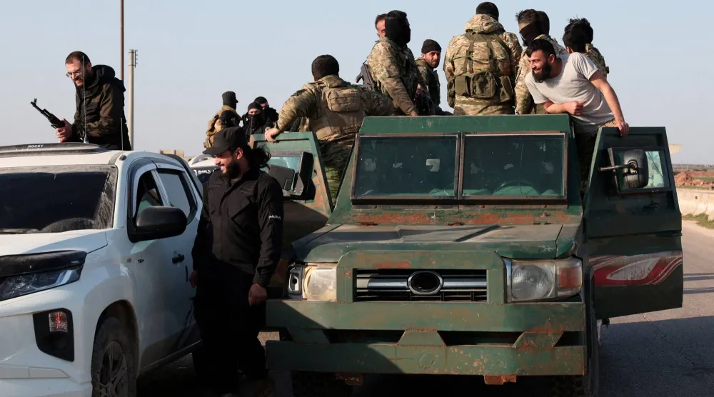 أفراد من الجيش السوري يتجهون نحو اللاذقية للانضمام إلى القتال ضد فلول الأسد في حلب (رويترز)