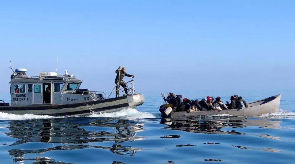 خفر السواحل التونسي يحاول إيقاف بعض المهاجرين في البحر أثناء محاولتهم العبور إلى إيطاليا (أرشيفية - رويترز)