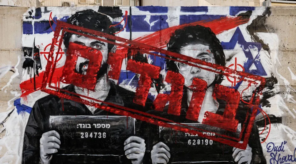 رسم على جدار في أسدود بجنوب إسرائيل يصور مخرجَيْ فيلم «نازا» وقد كُتبت عليهما كلمة «خائنان» بالعبرية (رويترز)