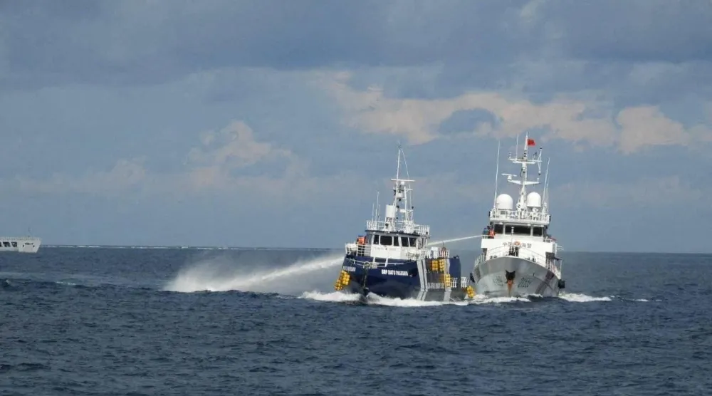 سفينة خفر السواحل الصينية (يميناً) تطلق مدفع مياه على السفينة الفلبينية «BRP Datu Pagbuaya» قرب جزيرة Pag-asa في بحر الصين الجنوبي 12 أكتوبر 2025 (أ.ب)