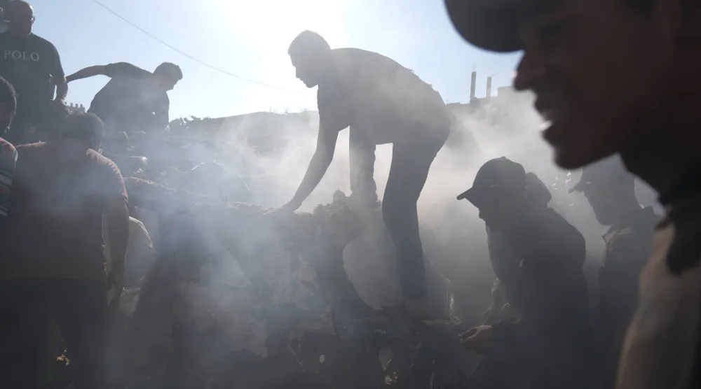  People operate on a destroyed vehicle following an Israeli airstrike in Gaza city, Saturday, Sept. 19, 2026. (AP) 