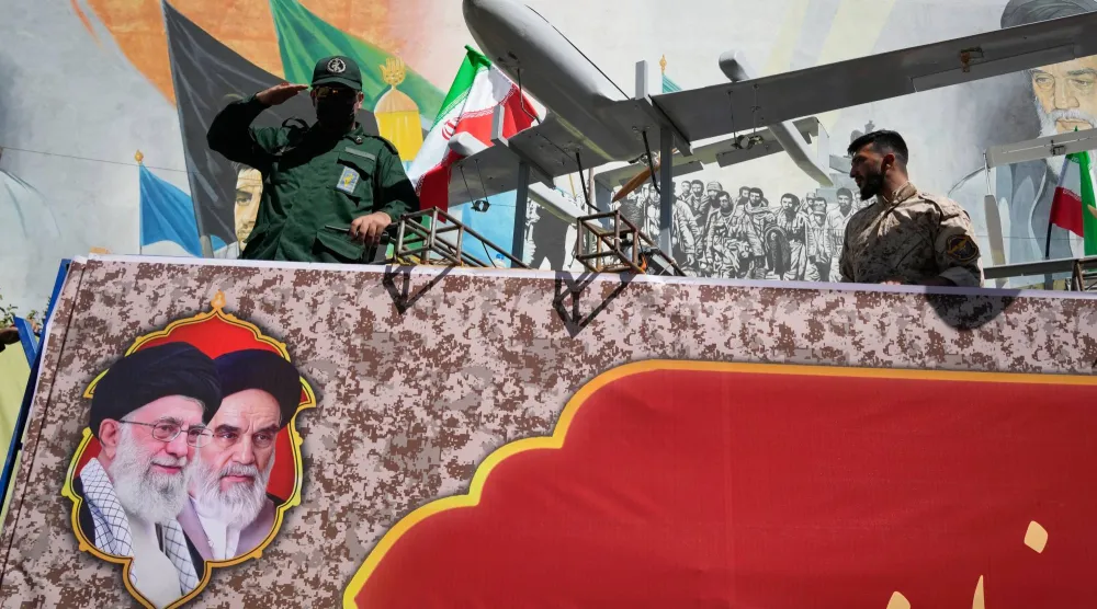 A member of Iran's Revolutionary Guard salutes while riding on a float displaying drones during the state-organized "Janfada," or "Sacrifice for Iran," military-style parade in Tehran, Iran, Friday, Sept. 18, 2026. (AP Photo/Vahid Salemi)
