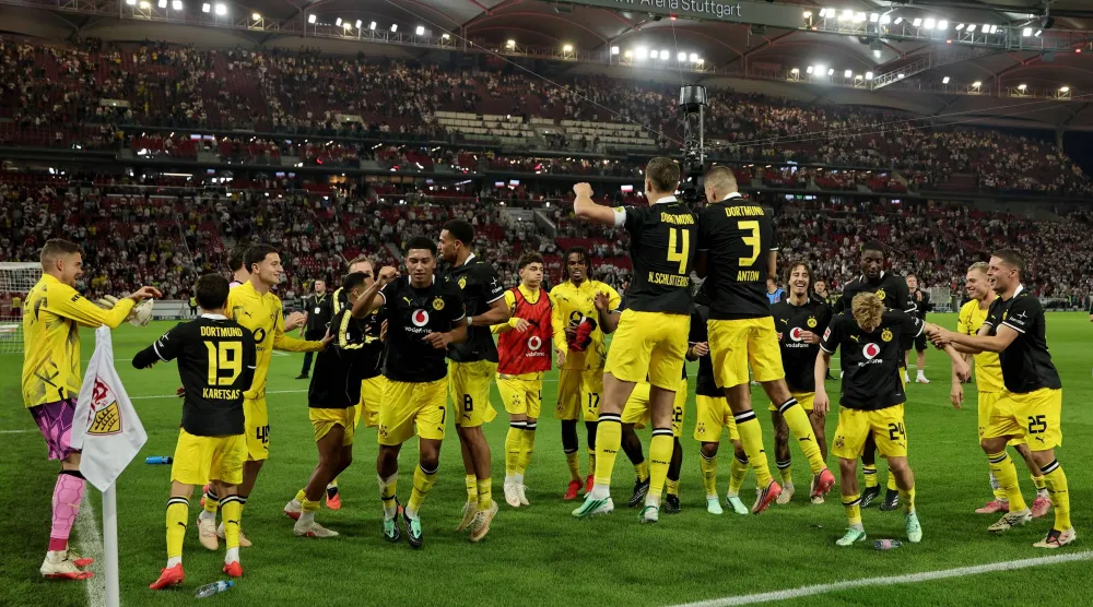 لاعبو بوروسيا دورتموند يحتفلون بالفوز على شتوتغارت وضمان الصدارة (إ.ب.أ)
