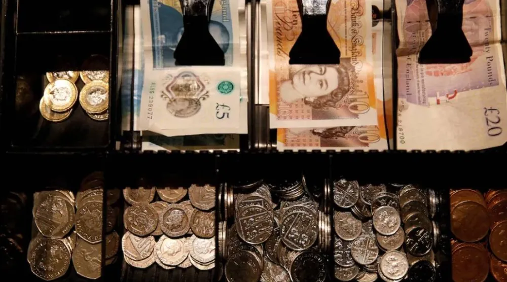 أوراق وعملات بالجنيه الإسترليني داخل صندوق نقود في مقهى بمانشستر - بريطانيا (رويترز)
