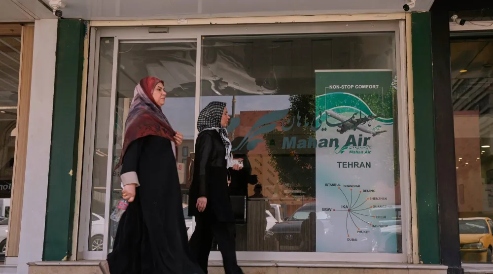 Pedestrians walk past an office of Iranian airline Mahan Air in Baghdad, Iraq, Wednesday, Sept. 23, 2026. (AP Photo/Hadi Mizban)