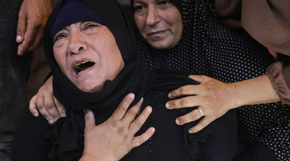 أم فلسطينية تبكي ابنها خلال جنازته الأربعاء بعد مقتله بغارة إسرائيلية في خان يونس جنوب غزة (أ.ف.ب)