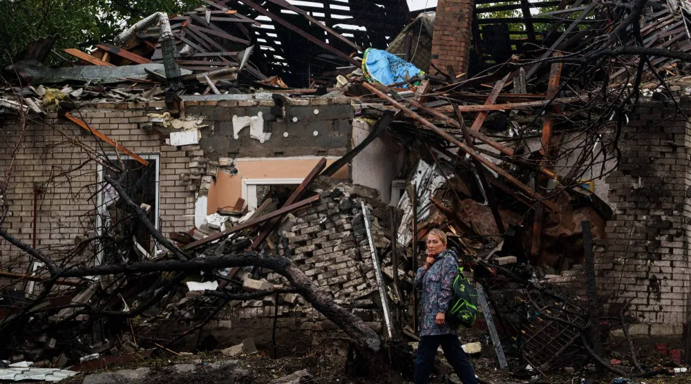 A woman walks in front of a house destroyed in a Russian strike on a residential neighbourhood in Kyiv, Ukraine, Thursday, Sept. 24, 2026. (AP Photo/Evgeniy Maloletka)