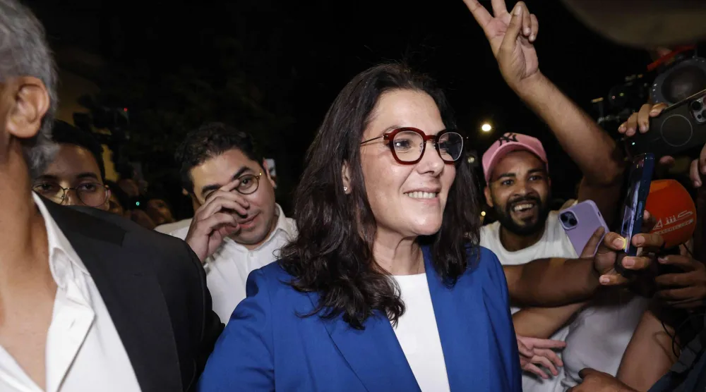 فاطمة الزهراء المنصوري عضوة القيادة الجماعية لحزب «الأصالة والمعاصرة» وسط أنصارها المحتفلين بنتائج الانتخابات فجر الخميس (أ.ف.ب)