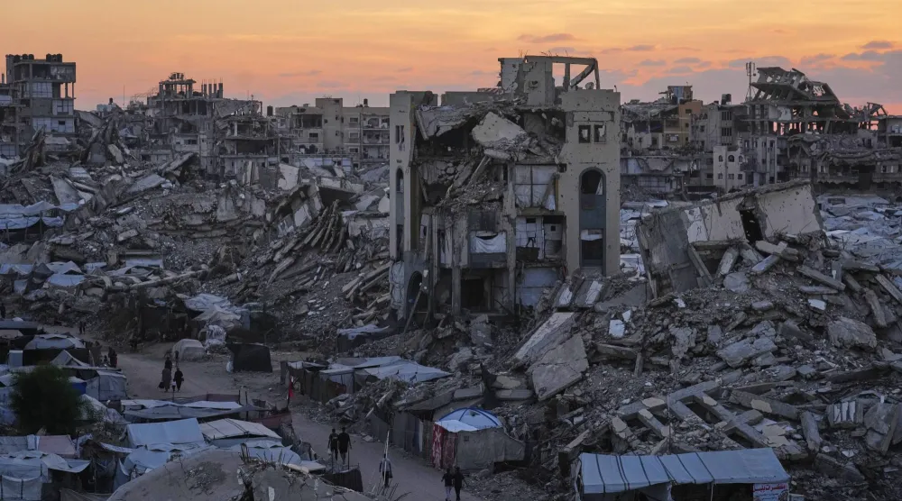 Palestinians walk amid war-damaged buildings in Gaza City, Wednesday, Sept. 23, 2026. (AP Photo/Jehad Alshrafi)
