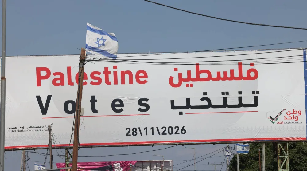 لافتة عن الانتخابات التشريعية الفلسطينية في شارع قرب مدينة جنين بالضفة الغربية يوم الجمعة (إ.ب.أ)
