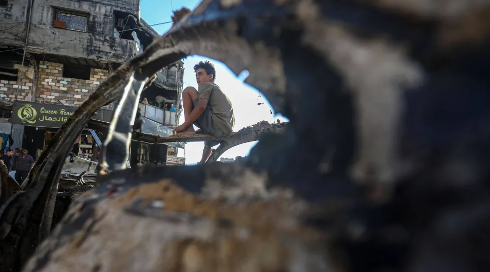 فلسطينيون يتجمعون بموقع تعرض لضربة إسرائيلية في حي الشيخ رضوان بقطاع غزة الأسبوع الماضي (د.ب.أ)