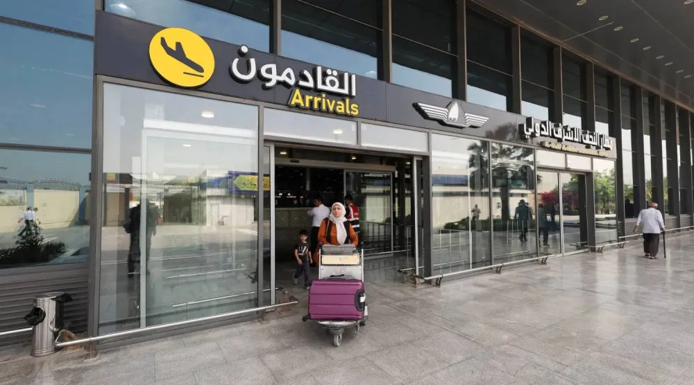 مسافرة إيرانية تحمل أمتعتها تغادر مطار النجف الدولي في النجف بالعراق يوم 23 سبتمبر 2026 (رويترز)
