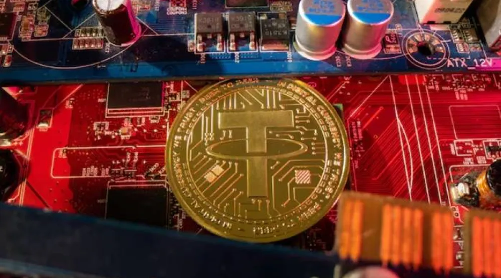 تمثيل للعملة الرقمية «تيثر» موضوع على لوحة أم لجهاز حاسوب (رويترز)