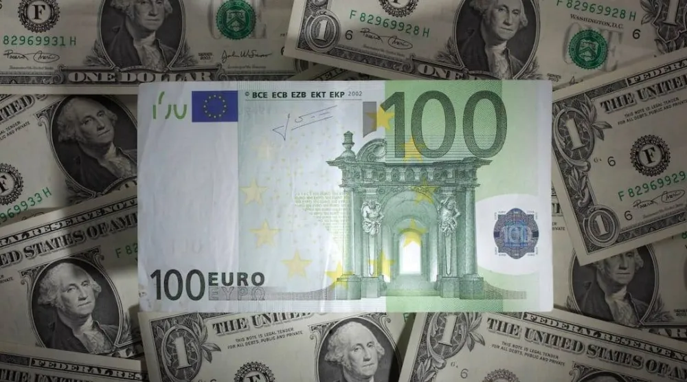 ورقة نقدية من فئة 100 يورو فوق أوراق نقدية من فئة دولار واحد في وارسو (رويترز)