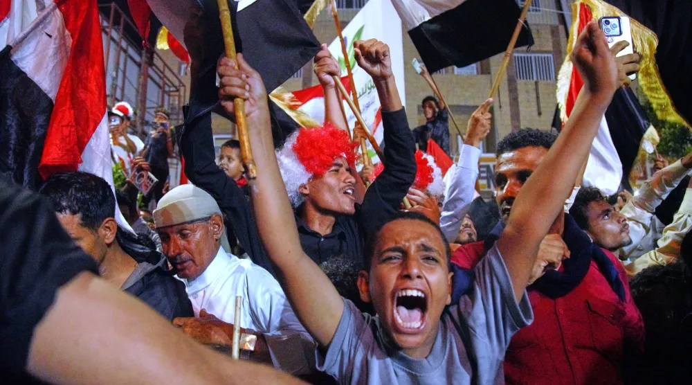 يمنيون يلوّحون بالعَلم الوطني خلال احتفال في تعز بذكرى الثورة اليمنية (أ.ب)