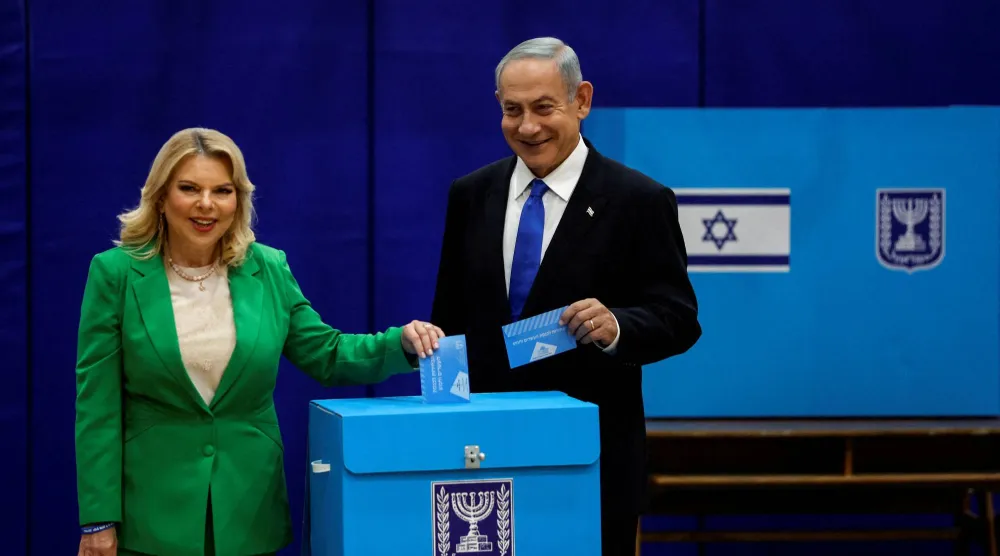 رئيس الوزراء الإسرائيلي السابق بنيامين نتنياهو يقف إلى جانب زوجته سارة في أثناء الإدلاء بصوتيهما في يوم الانتخابات العامة الإسرائيلية وذلك في مركز اقتراع بالقدس في الأول من نوفمبر 2022 (رويترز)