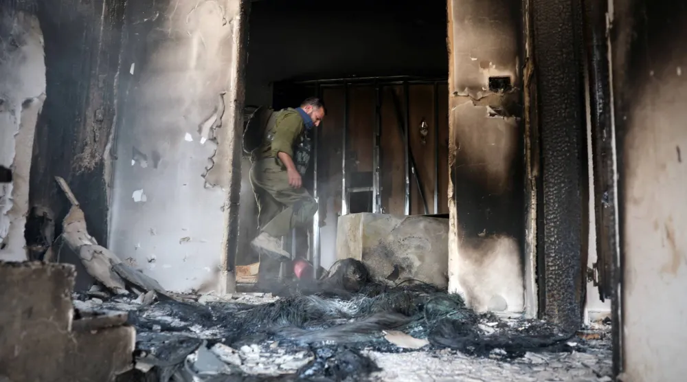 جندي إسرائيلي داخل منزل مملوك لفلسطينيين في الضفة الغربية بعد تعرضه لهجوم وإحراقه من قبل مستوطنين إسرائيليين يوم الثلاثاء (رويترز)