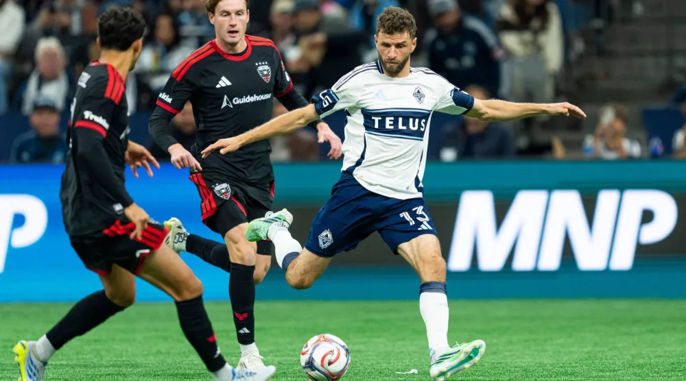 Thomas Muller #13 of the Vancouver Whitecaps FC takes a shot on goal while being defended against by Andre Dozzell #21 and Kye Rowles #15 of DC United during the second half of MLS action at BC Place on September 26, 2026 in Vancouver, Canada. (Getty Images/AFP)
