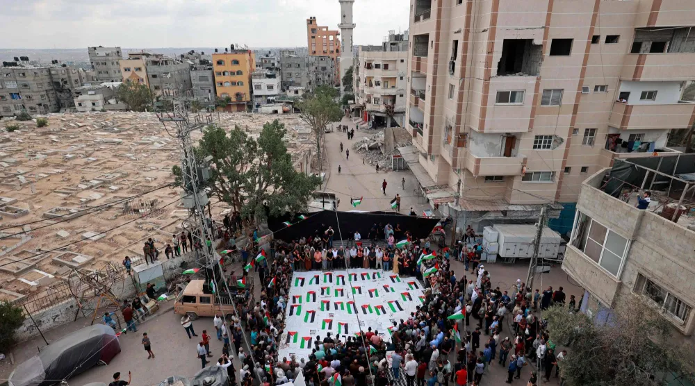 فلسطينيون خلال جنازة جماعية وسط قطاع غزة أمس بعد انتشال 41 جثة من تحت أنقاض مبنى تعرض لغارة إسرائيلية في أكتوبر 2023 (أ.ف.ب)