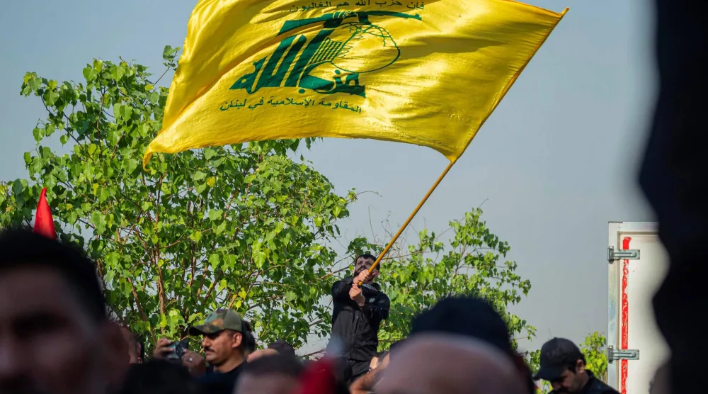 رجل يلوّح بعلم «حزب الله» اللبناني في بغداد خلال الذكرى الثانية لاغتيال أمين عام الحزب حسن نصر الله... 26 سبتمبر 2026 (أ.ف.ب)