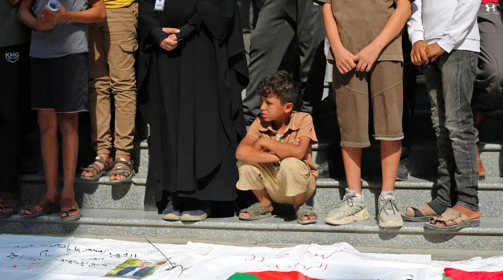 صبي فلسطيني يتبع المشيعين في جنازة جماعية في مخيم النصيرات للاجئين وسط قطاع غزة (أ.ف.ب)