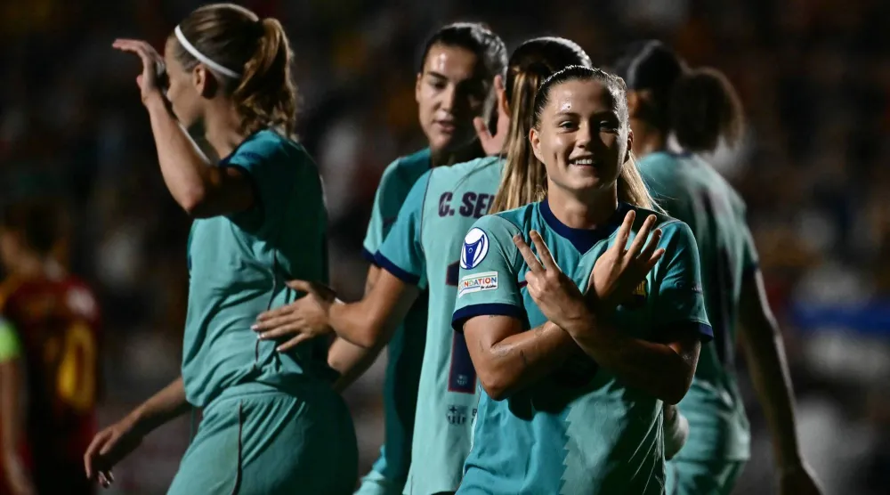 كلاوديا بينا تحتفل مع زميلاتها بعد تسجيلها خلال فوز برشلونة على روما في دوري أبطال أوروبا للسيدات (أ.ف.ب)
