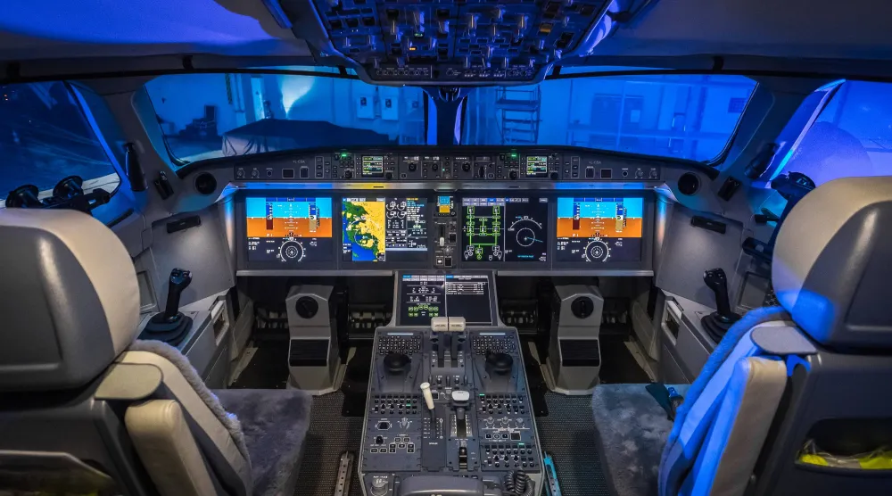 صورة توضح البنية الهندسية لقمرات القيادة الحديثة (Glass Cockpits) حيث تنتشر الشاشات الرقمية المتقدمة، وتظهر لوحة التحكم المركزية (Center Pedestal) الواقعة بين مقعدي القبطان والمساعد. في هذه المنطقة تحديداً، يتواجد جهاز الإرسال والاستقبال (Transponder) الذي يستخدمه الطيارون لطباعة رموز الطوارئ الثلاثية (7700، 7600، 7500) لتظهر فوراً على رادارات المراقبين الأرضيين (ويكيبيديا)