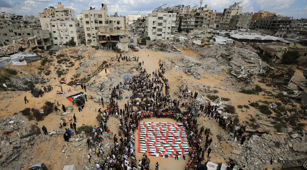 مشيعون يحضرون جنازة جماعية لفلسطينيين انتُشلت جثامينهم من تحت أنقاض مبنى سكني تعرض لضربة إسرائيلية في أكتوبر 2023 -وفقاً للدفاع المدني- وذلك في مدينة غزة اليوم (رويترز)